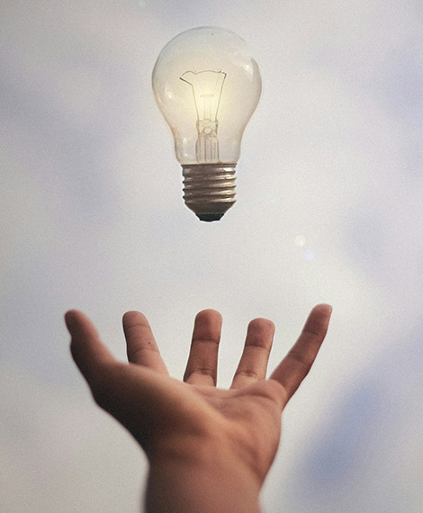 Una mano aperta verso l'alto fa fluttuare una lampadina accesa